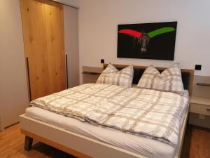 a bedroom with a bed with a plaid comforter at Panorama Alpendorf in Sankt Johann im Pongau