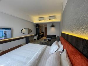 a hotel room with a bed and a desk at Ruby Apartment #4 in Kejayan