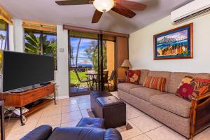 a living room with a couch and a flat screen tv at Kamaole Beach Club C109 in Kihei