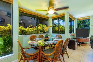 a dining room with a table and chairs and a ceiling fan at Kamaole Beach Club C109 in Kihei