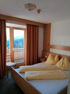 a bedroom with two beds and a large window at Pension Lucknerhof in Maranza