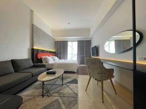 een woonkamer met een bank en een bed bij Ruby Apartment #4 in Kejayan