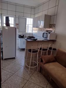 een keuken met een koelkast en een aanrecht met krukken bij Apartamento Avenida 01 in São Thomé das Letras