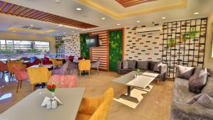 ein Restaurant mit Tischen und Sofas und ein Esszimmer in der Unterkunft The Palm Hotel in Kafr EL Sheikh