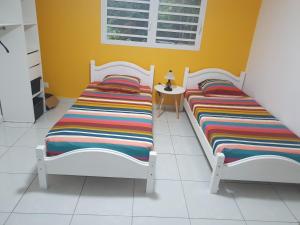 dos camas sentadas una al lado de la otra en una habitación en L'échappée belle, en Port-Louis