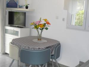 a table with a vase of flowers on it at Petit coin de paradis. in Six-Fours-les-Plages