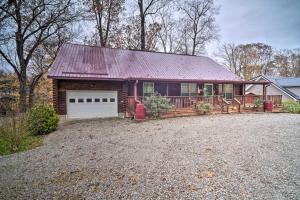 a house with a large driveway in front of it at Woodsy Kentucky Escape with Game Room and Lake Access! in Burnside