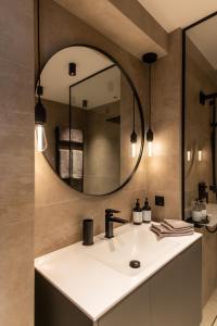 Residenz Boutique Suites في باد جاستاين: حمام مع حوض ومرآة