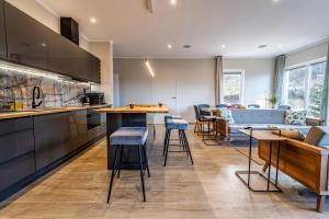 a kitchen with a bar and some stools in it at MONTEZERA Butikowe Ekspedycje Sauna i Widok in Piechowice