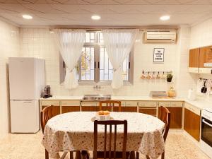a kitchen with a table with chairs and a refrigerator at Casa Mayor in Tous