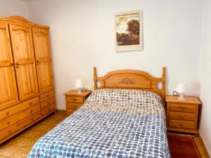1 Schlafzimmer mit einem Bett und 2 Holzschränken in der Unterkunft Casa Mayor in Tous