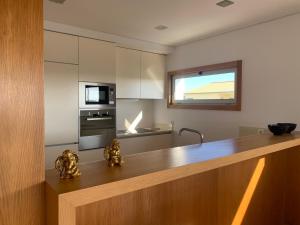 a kitchen with a wooden counter top in a room at T2 Dunas Esposende in Esposende