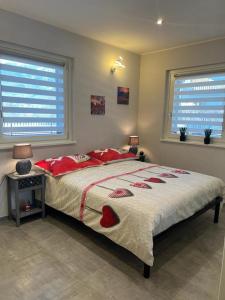 a bedroom with a large bed and two windows at Villa Kate in Aosta