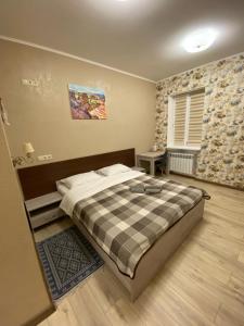 a bedroom with a bed with a plaid blanket at Вігвам in Poltava