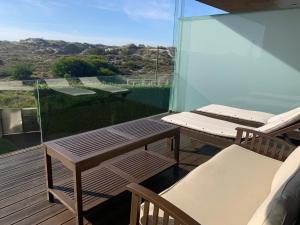 a balcony with a table and chairs and the ocean at T2 Dunas Esposende in Esposende