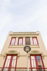 a building with red windows and a clock in front of it at Mapango Small Rooms in Santa Cruz de Tenerife