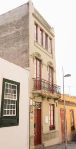 a building with red doors and a balcony at Mapango Small Rooms in Santa Cruz de Tenerife
