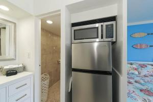 a kitchen with a stainless steel refrigerator with a microwave at Room 127 - Waterfront, Heated Pool, Huge TV, Tiki Bar & Grill in Sarasota