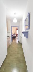 グラナダにあるCÓMODO APARTAMENTO EN CENTRO HISTORICOの白壁のキッチンにつながる廊下