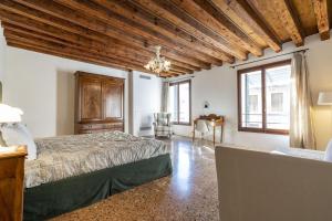 a bedroom with a bed and a desk and windows at Sensale in Venice