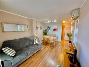 uma sala de estar com um sofá e uma mesa em SeaHomes Vacations, LA MER BLEUE, beach&pool, PK, full equipped in Fenals Beach em Lloret de Mar