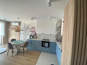 a kitchen with a table and a table and chairs at Baltic Apartment Posesja Kapitańska in Grzybowo