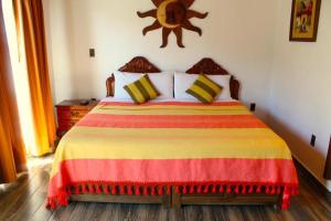 
a bedroom with a bed and a dresser at El Molino de Allende Guest House in San Miguel de Allende
