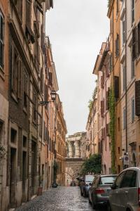 una strada di ciottoli in una città con edifici di Colosseum Townhouse a Roma