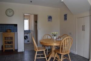 a dining room with a wooden table and chairs at Maytham Cottage in Rye