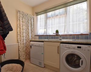 a kitchen with a washing machine and a window at Maytham Cottage in Rye