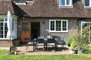 a patio with a table and chairs in front of a house at Maytham Cottage in Rye +33 photos