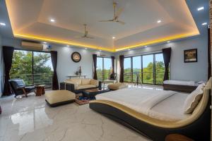 um quarto grande com uma cama grande num quarto com janelas em SaffronStays Aura, Alibaug - luxury pool villa with a game room and spacious lawn em Alibaug