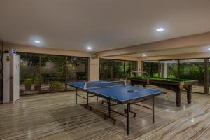 uma sala grande com duas mesas de pingue-pongue em SaffronStays Aura, Alibaug - luxury pool villa with a game room and spacious lawn em Alibaug