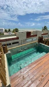 - une piscine au-dessus d'un bâtiment à côté de la plage dans l'établissement Casa Rústica com Rooftop e 2 Piscinas - 100mts do Mar - Rota dos Milagres, à São Miguel dos Milagres