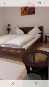two beds in a room with a table and a picture at APARTMAN MILICA in Požarevac