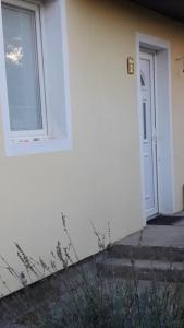 a white building with a window and a door at APARTMAN MILICA in Požarevac