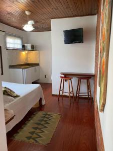 a bedroom with a bed and a table with two stools at Morada das Pedras in Florianópolis