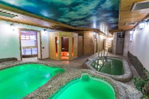 a house with a swimming pool with a ceiling covered in clouds at Spa-Hotel Myslyvskiy Dvir in Kyiv