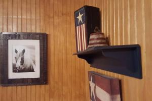 a wall with pictures and a tv and a flag at Cabin 2 - Modern Cabin Rentals in Southwest Mississippi at Firefly Lane in Summit