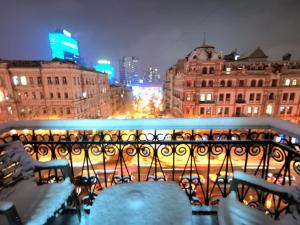 einen Blick auf die Stadt in der Nacht vom Balkon aus in der Unterkunft Яркая история in Kiew