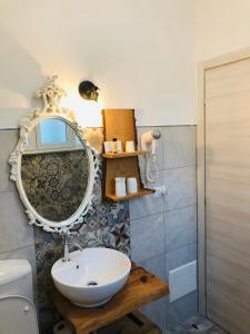 a bathroom with a sink and a mirror on the wall at Rial Maison in Bergamo