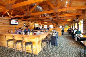a restaurant with tables and chairs and people at Denali Bluffs Hotel in McKinley Park