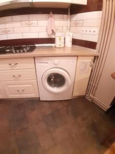 a white kitchen with a washing machine in it at Apartament Mario in Sibiu