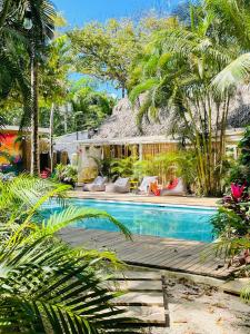 a swimming pool with palm trees and a house at Norte Nosara - Steps to Playa Guiones in Nosara