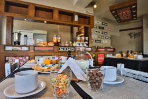 una mesa con tazas y platos de comida. en Trip Bariloche Select en San Carlos de Bariloche