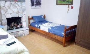 um quarto com uma cama e uma lareira em Argiris Old City House 1 em Kalabaka