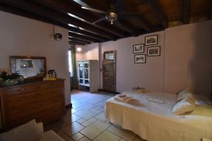 a bedroom with a bed and a dresser and a television at B&B Il Melograno del Garda in Padenghe sul Garda