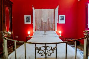 1 dormitorio con 1 cama con paredes rojas y 2 lámparas en Monreal Boutique Townhouse - R024RM4 en Paola