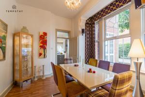 a dining room with a table and chairs and a window at LUXURY HOME - CENTRAL WINDSOR, GATED PARKING in Windsor