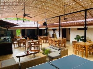 a restaurant with wooden tables and chairs and tables and tablesktop at Hotel Ocotal Bed & Breakfast in Ocotal